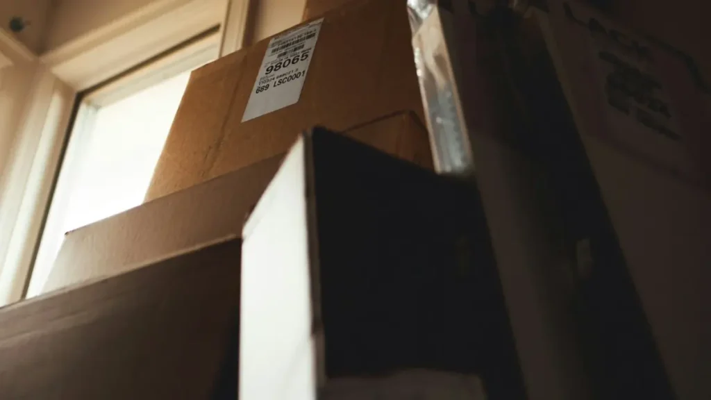 Cajas de cartón apiladas junto a una ventana