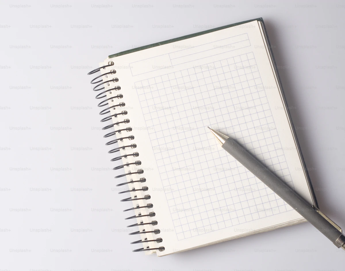 Libreta con lista de comprobación y un móvil sobre una mesa