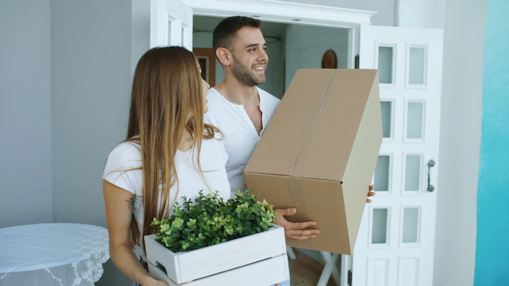 Pareja llevando cajas de mudanza